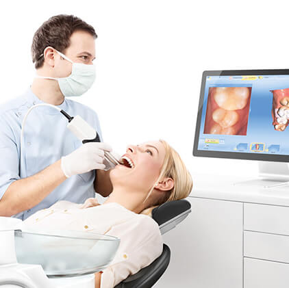 Dentist looking at patients smile images on computer screen