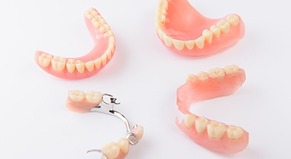 Full and partial dentures on white surface